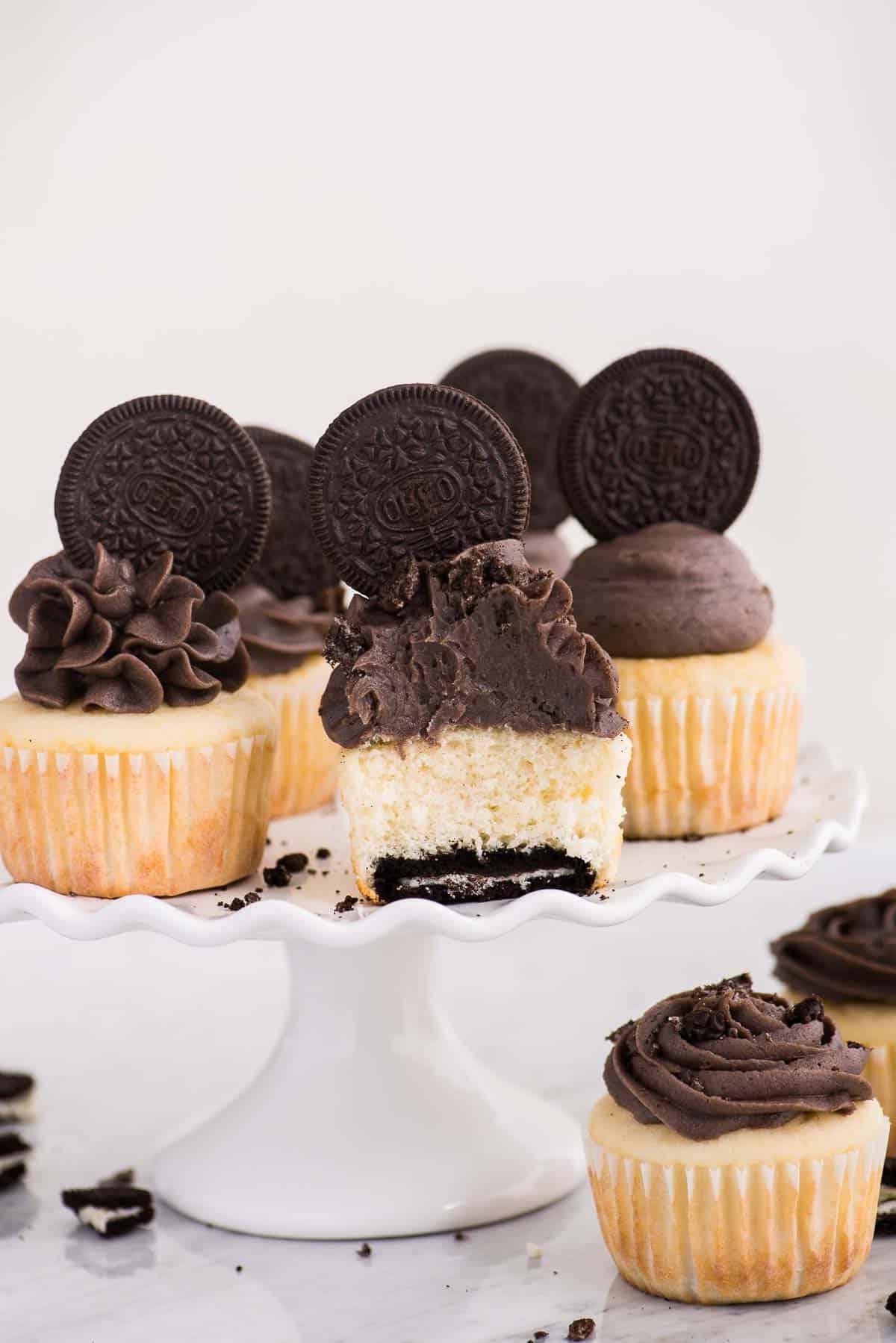Cupcakes con base Oreo 2 Cupcakes alla vaniglia con fondo Oreo su alzata bianca su sfondo bianco