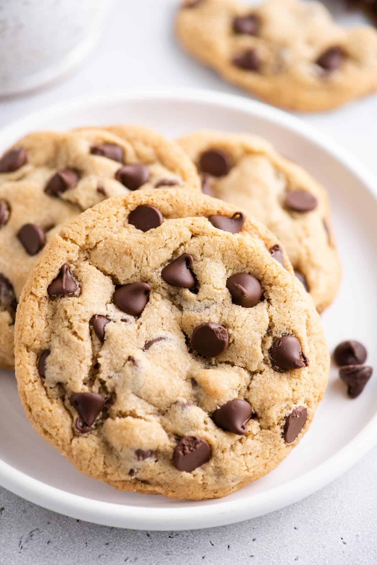 Se ami i biscotti morbidi e gommosi, adorerai questi biscotti con gocce di cioccolato in piccola quantità. Ne produce 6, perfetti per soddisfare una voglia! 3 biscotti con gocce di cioccolato morbidi su un piatto bianco