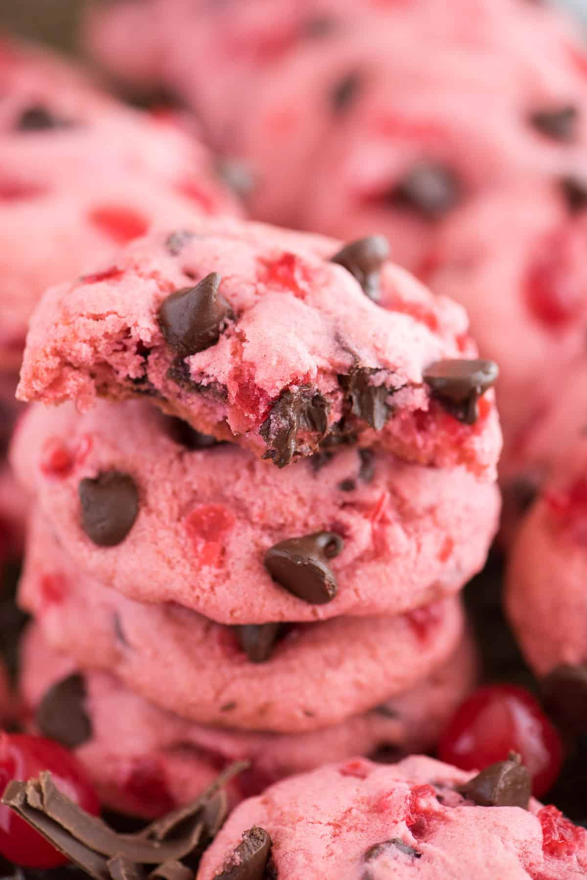 Ricetta di biscotti alle ciliegie maraschino spessi e masticabili! Ricetta di biscotti alle ciliegie candite. biscotti rosa alle ciliegie maraschino e gocce di cioccolato su teglia con ciliegie e gocce di cioccolato