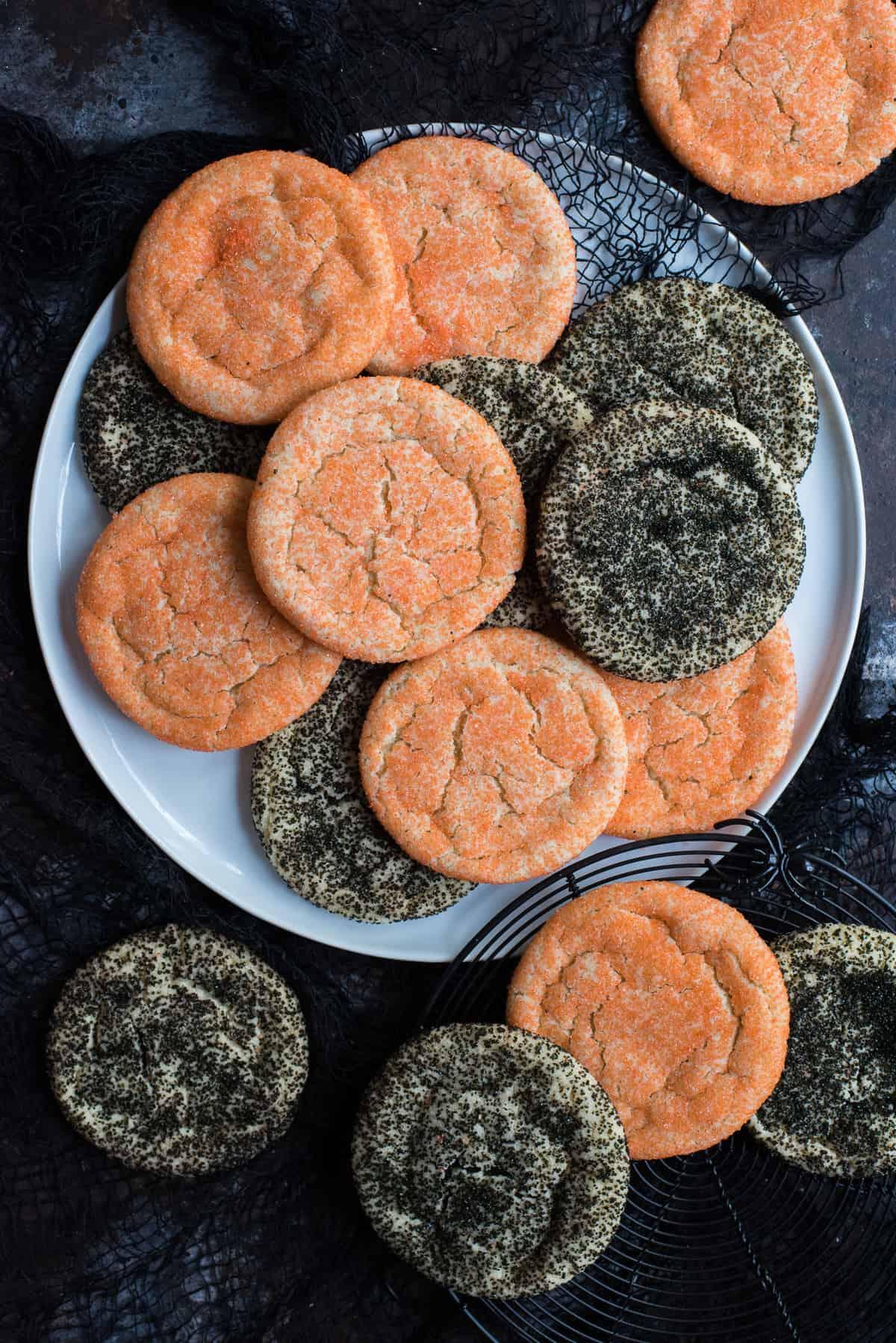 Semplici Biscotti di Zucchero di Halloween 2 Biscotti di zucchero neri e arancioni su piatto bianco su sfondo nero