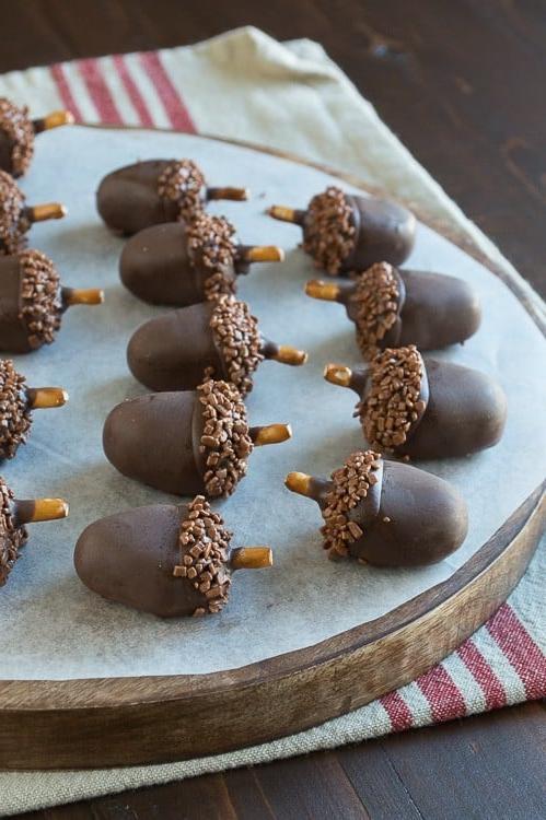 Palline Oreo a forma di ghianda 2 Adorabili e deliziose palline Oreo a forma di ghianda su un tagliere di legno rotondo.