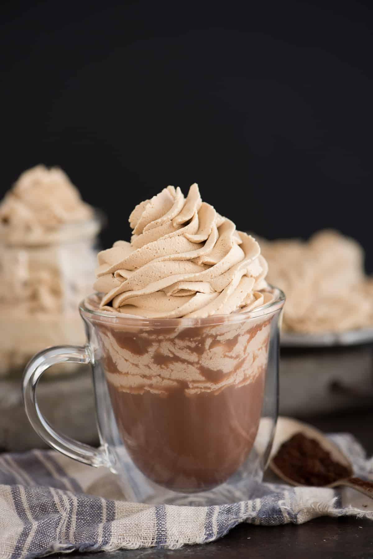 Panna montata al caffè con 3 ingredienti - tantissimi usi: torte, cupcake, frutta! Ora puoi gustare il tuo caffè, ma anche mangiarlo! #pannacaffe #pannafattaamano #pannadessert tazza di vetro con cioccolata calda e panna montata al caffè