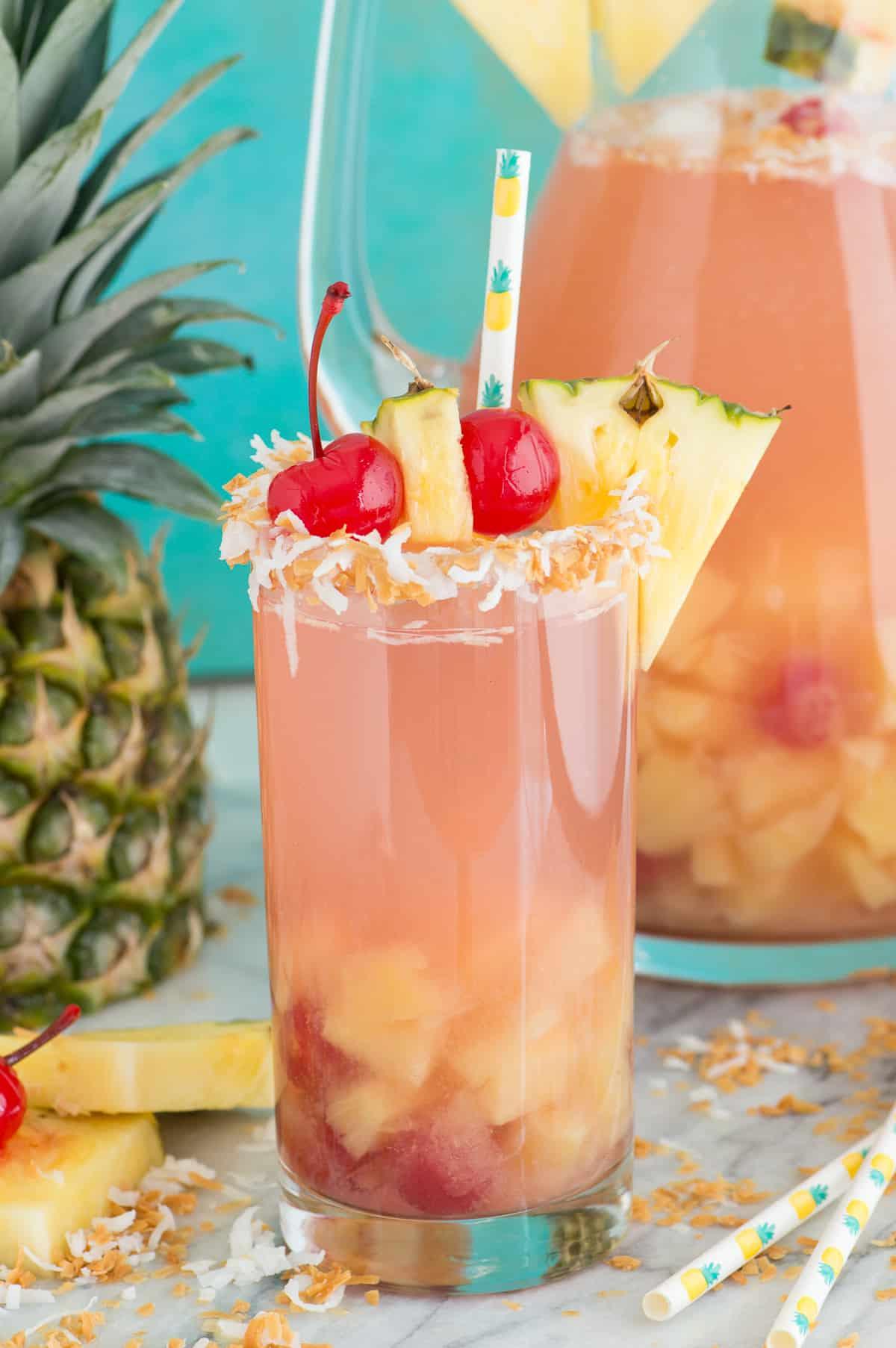 Pina Colada Sangria 2 Sangria Piña Colada in un bicchiere con guarnizione di ananas e ciliegia
