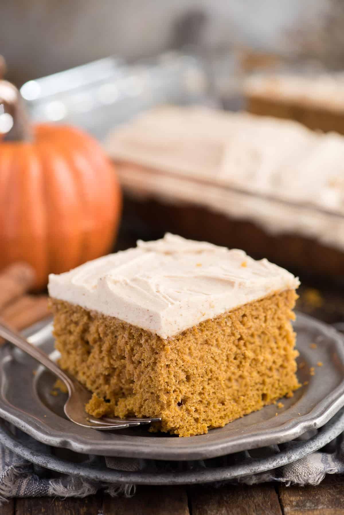 Facile Torta di Zucca da Mix 2 fetta di torta di zucca su piatto di metallo con zucca sullo sfondo
