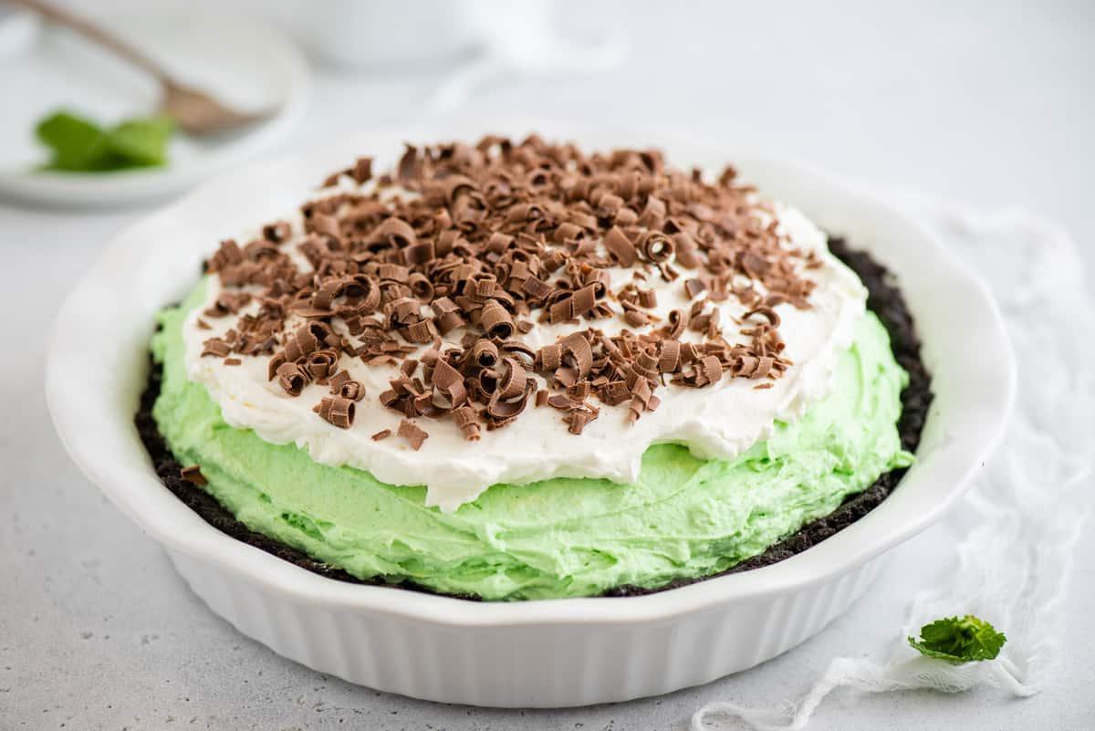 Torta Grasshopper Analcolica 2 Torta Grasshopper con riccioli di cioccolato in una teglia bianca su sfondo bianco