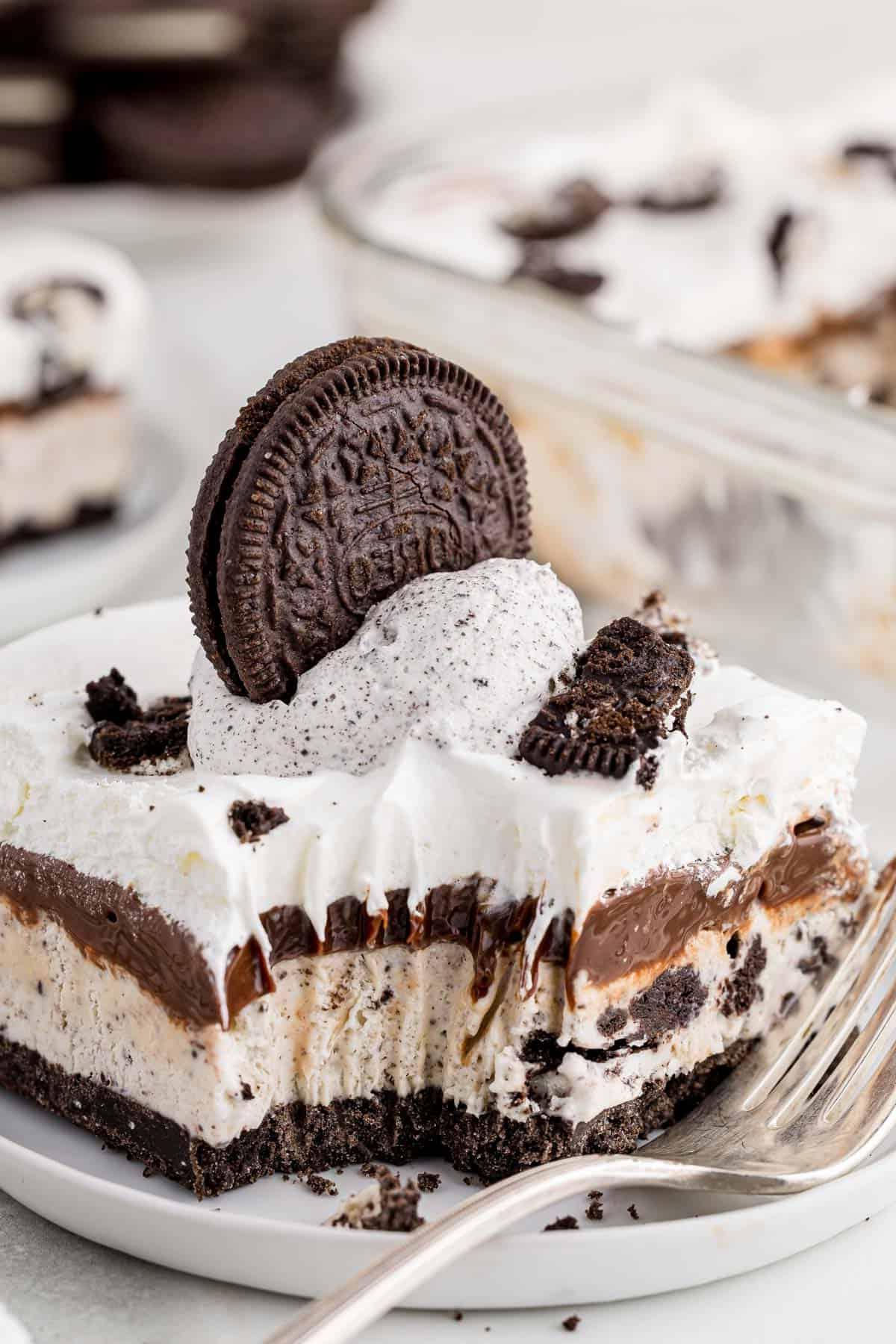 Ricetta Torta Gelato Oreo con 5 Ingredienti 2 Una fetta di torta gelato Oreo su un piatto bianco con un morso e una forchetta appoggiata sul piatto
