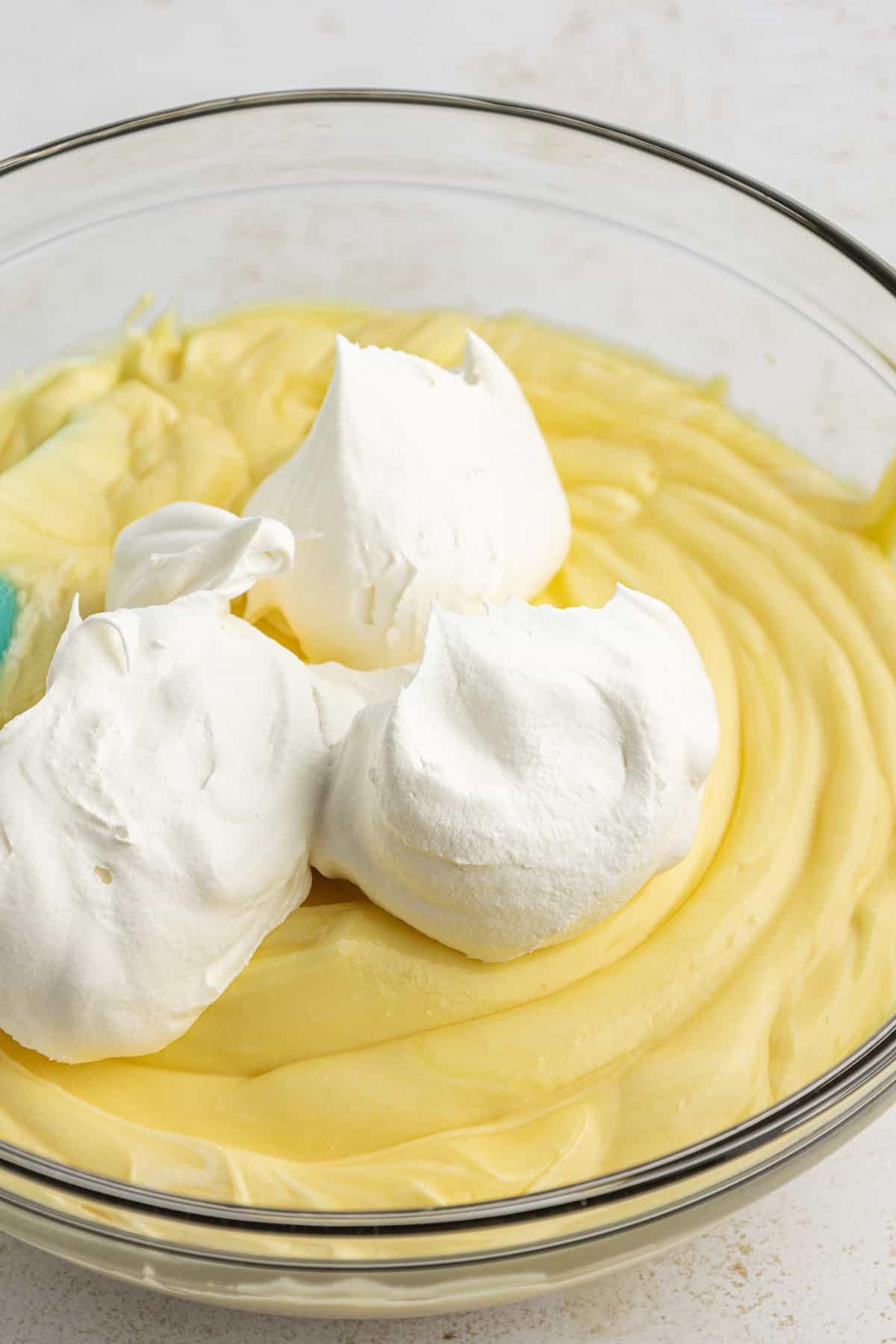 La migliore ricetta per la Torta al Fango 11 Miscela di budino istantaneo alla vaniglia in una ciotola di vetro trasparente guarnita con panna montata non ancora mescolata