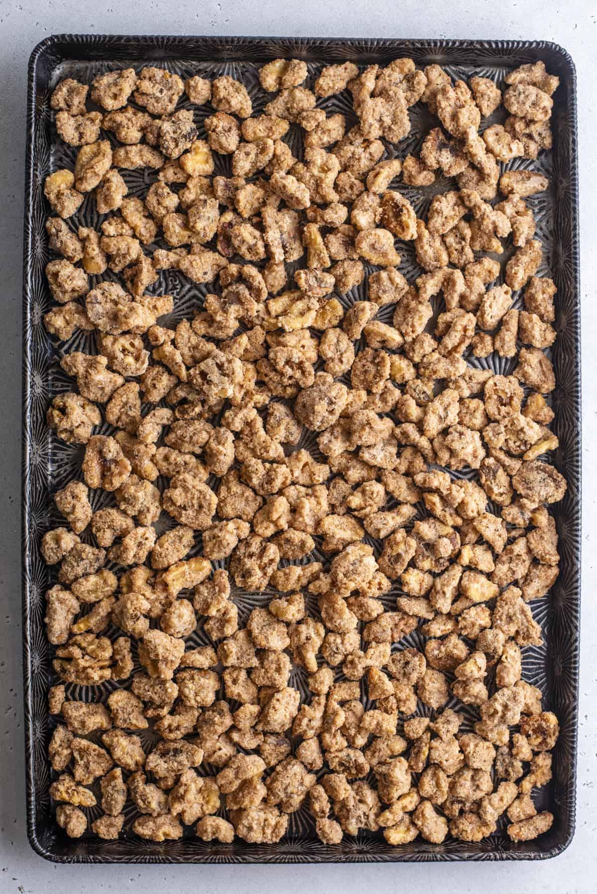 noci pralinate sparse su una teglia da forno