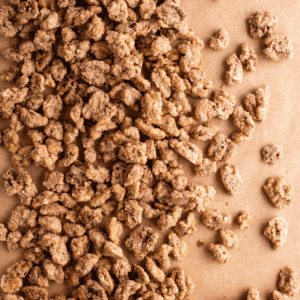 primo piano di noci pralinate sparse su carta marrone
