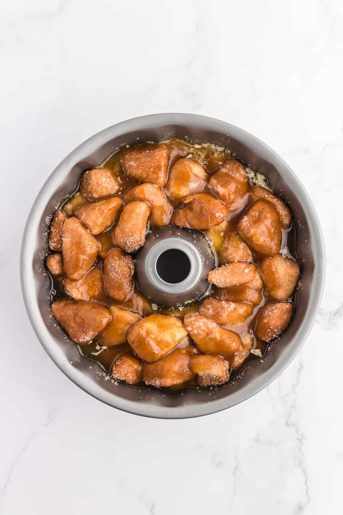 Pane delle scimmie di biscotti 12 Monkey Bread in uno stampo a ciambella appena prima di cuocere