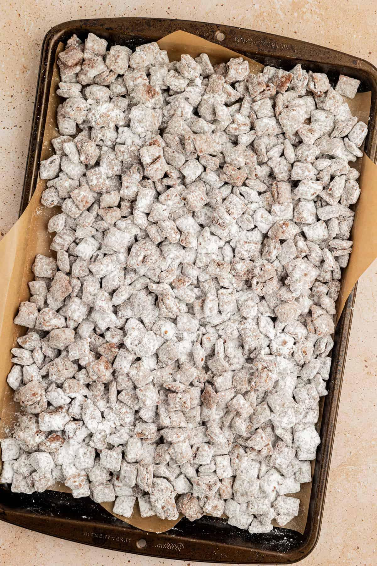 Una teglia foderata con carta da forno piena di puppy chow/muddy buddies