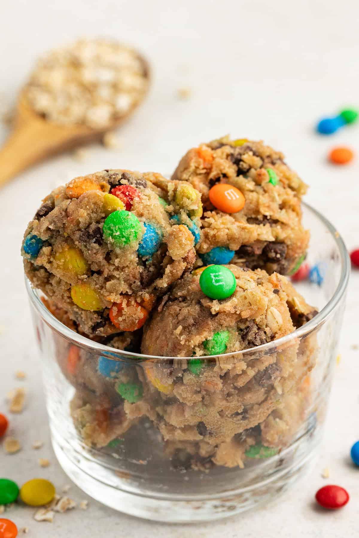 **Semplice Impasto per Biscotti Commestibile** 14 clear glass container of cookie monster cookie dough balls with oats and m&ms scattered around