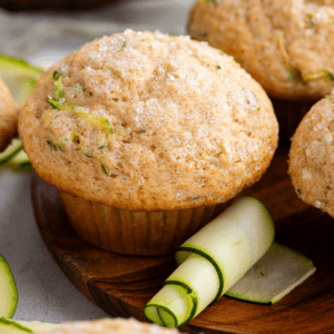 Migliori Muffin alle Zucchine 15 Muffin di zucchine su un piatto di legno con una buccia di zucchina arrotolata
