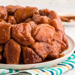 Pane delle scimmie di biscotti 16 Monkey Bread su un piatto bianco su un telo colorato a strisce