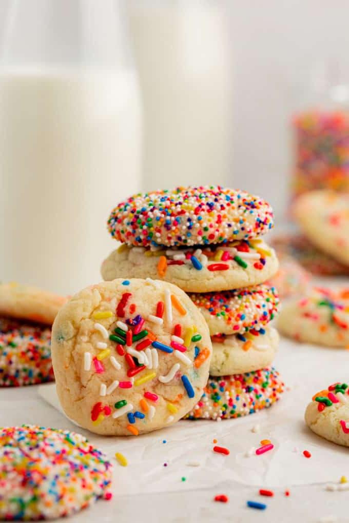Fare Biscotti dal Mix per Torte 17 Una pila di 5 biscotti Funfetti con preparato per torte con un altro biscotto appoggiato verticalmente sulla pila e altri biscotti Funfetti sparsi intorno