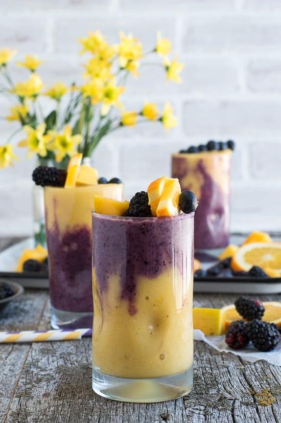 Questo smoothie hawaiano ai frutti di bosco a due strati presenta uno strato arancione al mango e uno strato ai frutti di bosco! Guarnisci lo smoothie con uno spiedino di frutta fresca!