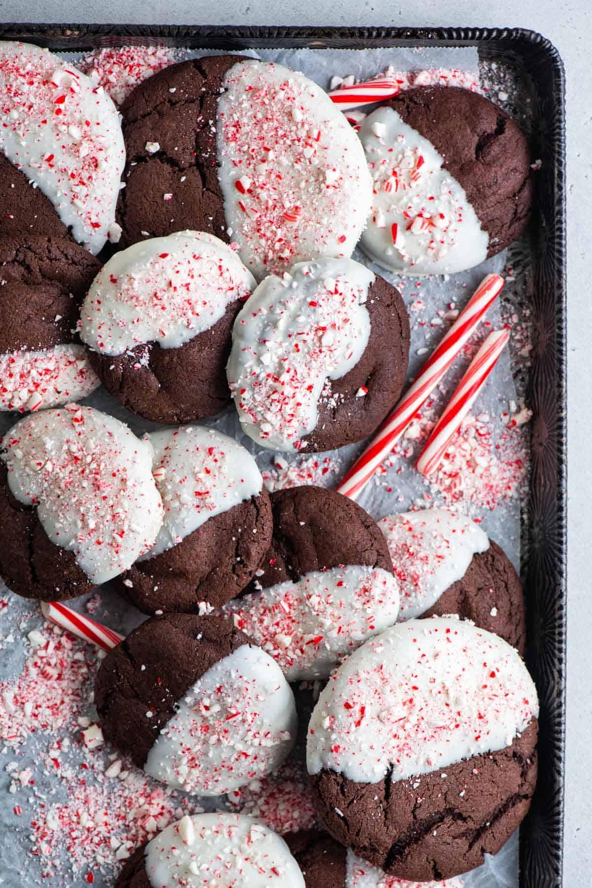 Questi Biscotti al Cioccolato e Bastoncini di Zucchero sono morbidi, gommosi, immersi nel cioccolato bianco e cosparsi di bastoncini di zucchero tritati. Vista dall'alto di biscotti al cioccolato e bastoncini di zucchero