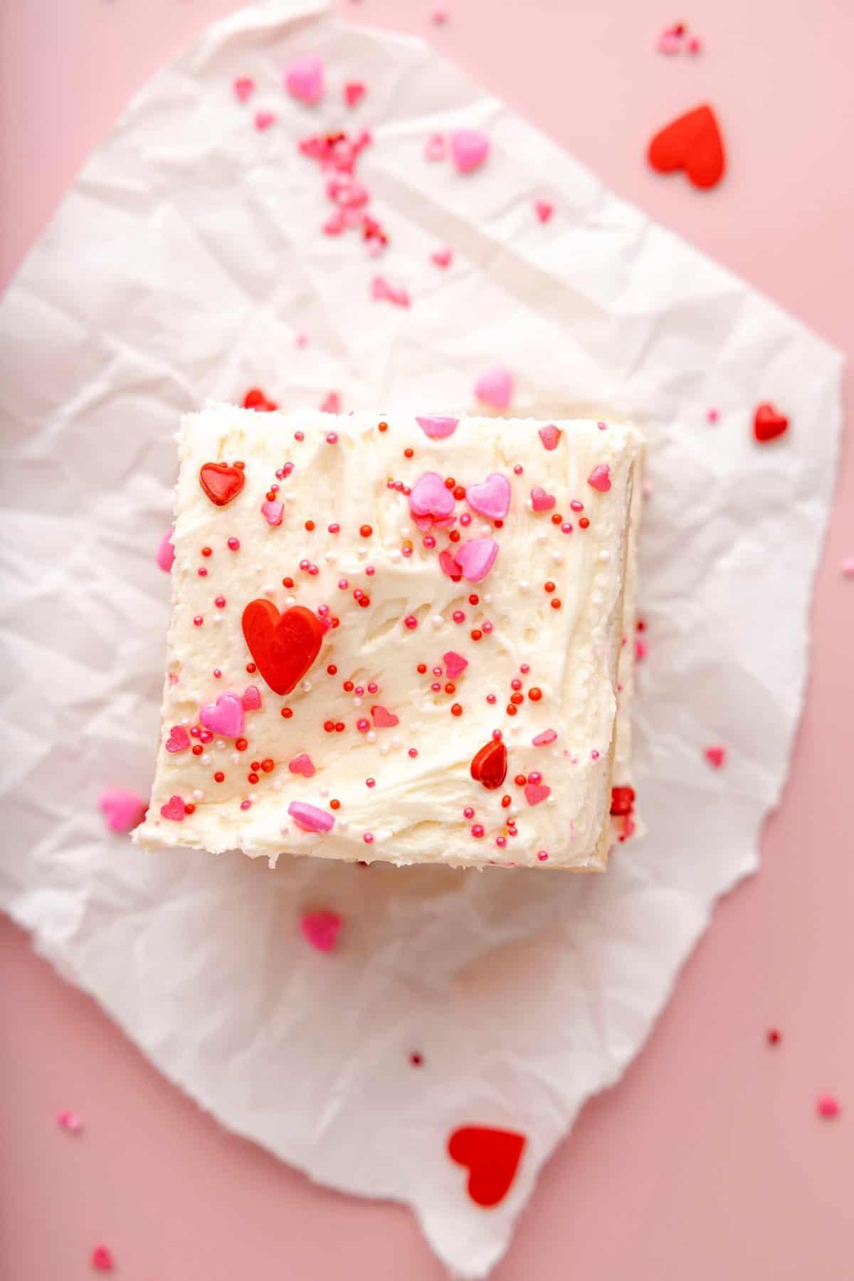 Quadrotti di Biscotti di Zucchero di San Valentino 3 due barrette di biscotto zuccherato con glassa bianca e confettini a tema San Valentino su sfondo rosa