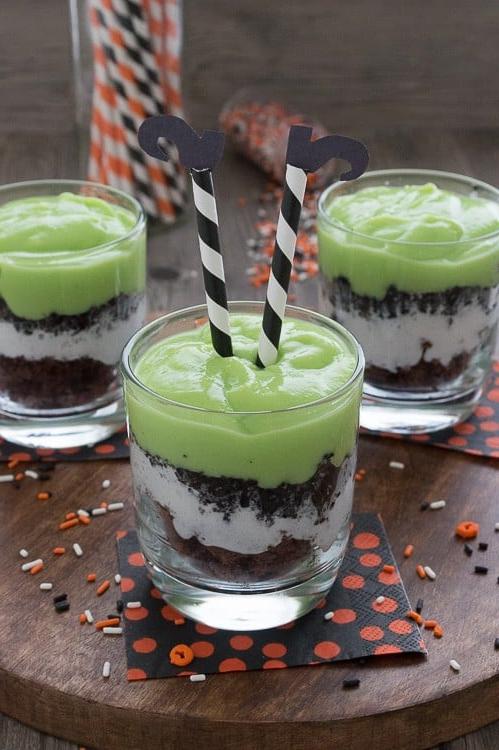 Festeggia Halloween con un parfait di budino. Mescola budino verde e aggiungi pezzi di brownie, panna montata e Oreo. Guarnisci il parfait con gambe di strega facili da realizzare!