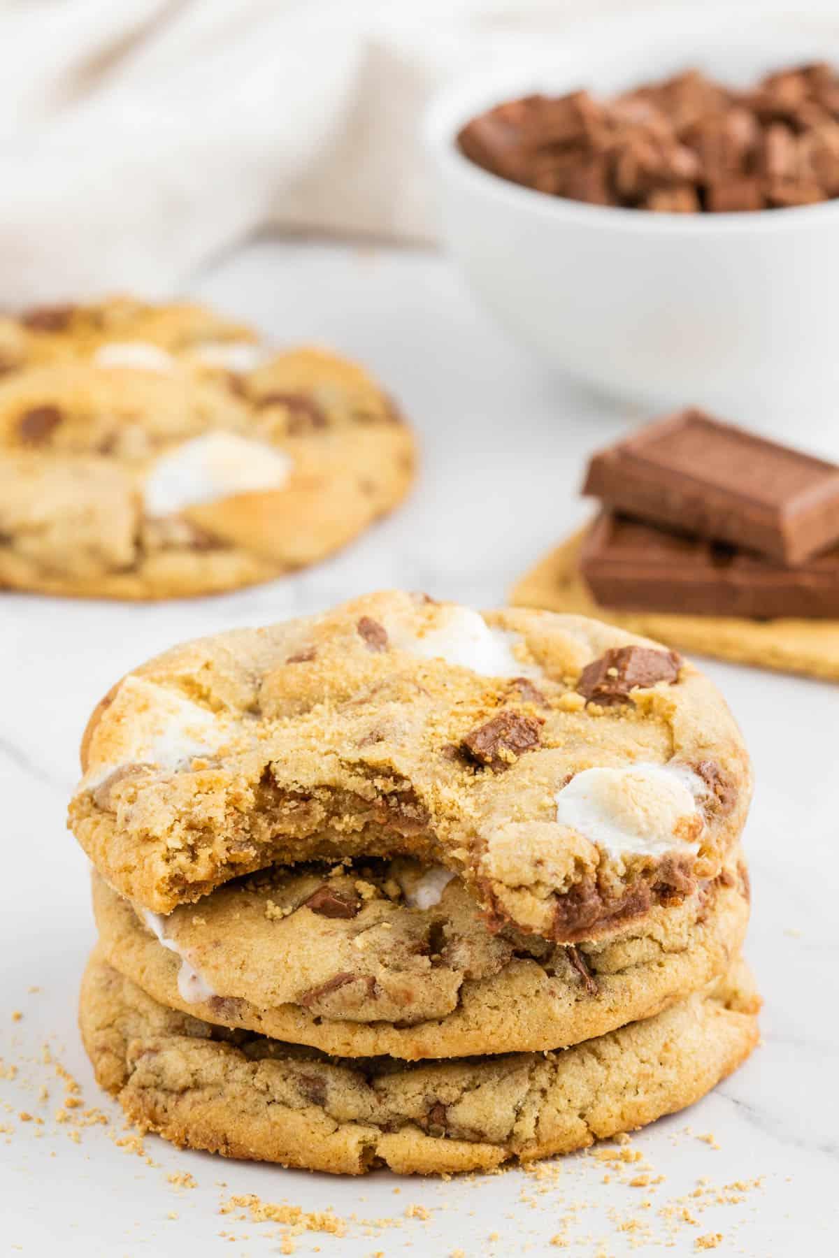 Ricetta Biscotti S'mores con Graham Crackers 3 una pila di tre biscotti s'mores con un morso dal biscotto superiore