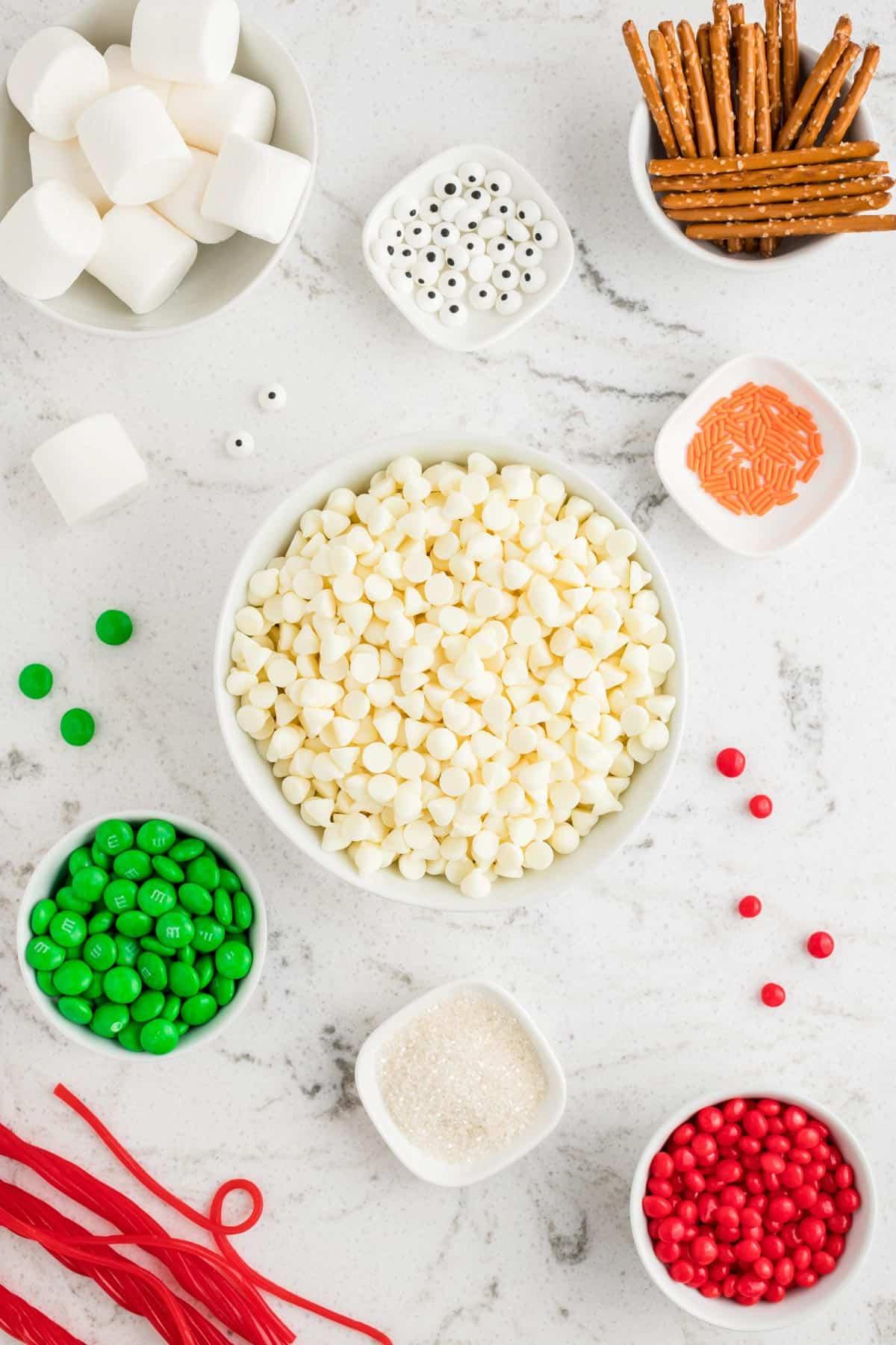 ingredienti per fare il bark pupazzo di neve in ciotole bianche su sfondo bianco