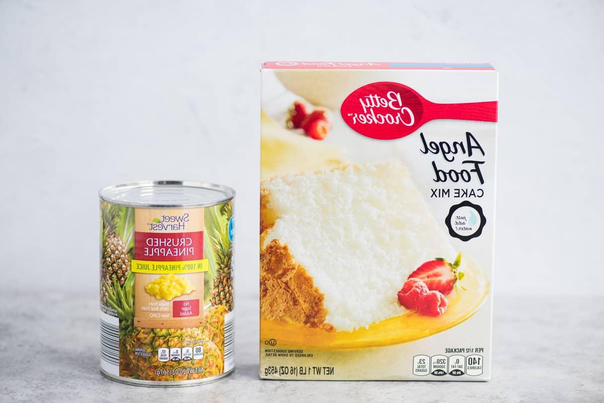 Scatola di preparato per Angel Food Cake e lattina di ananas schiacciato su sfondo bianco