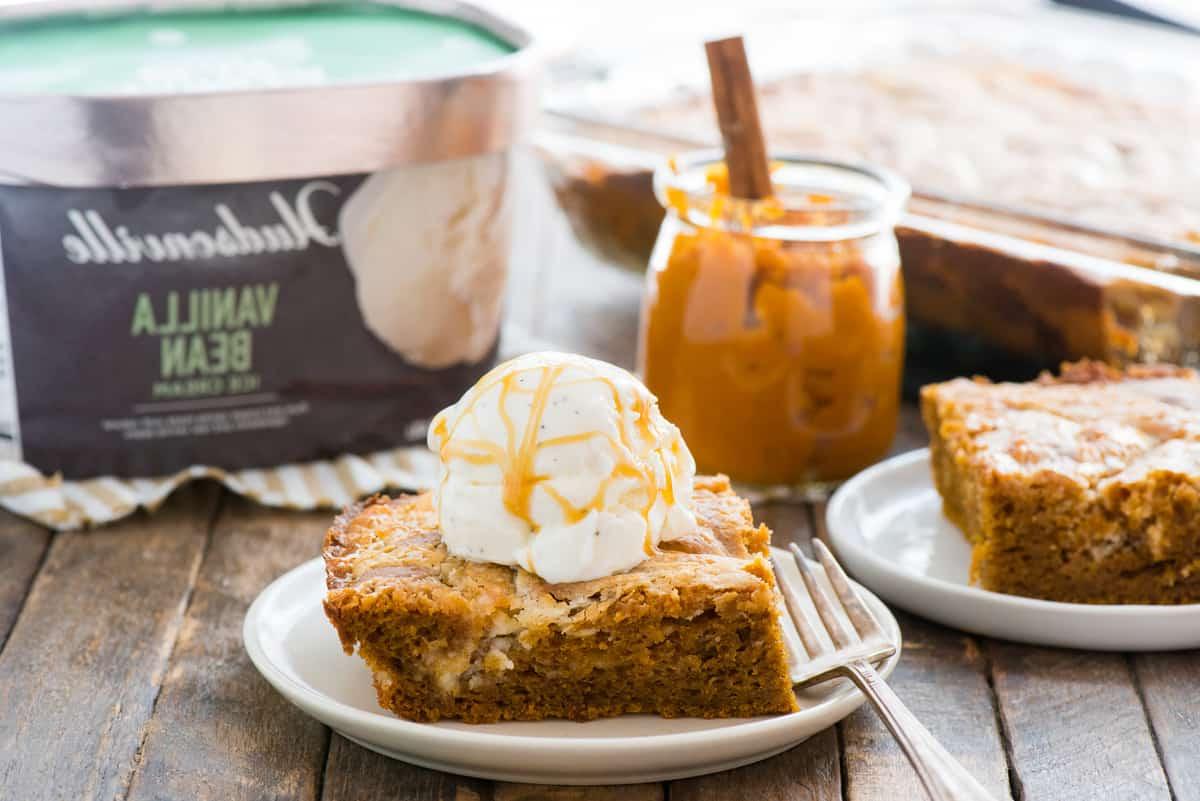 Fetta di torta terremoto alla zucca su piatto bianco con una pallina di gelato alla vaniglia sopra