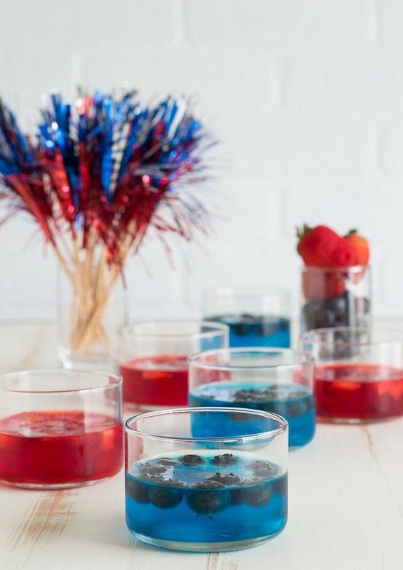 Coppette di Frutta e Gelatina per il 4 Luglio 4 Bicchierino di gelatina blu in tazza di vetro su sfondo bianco
