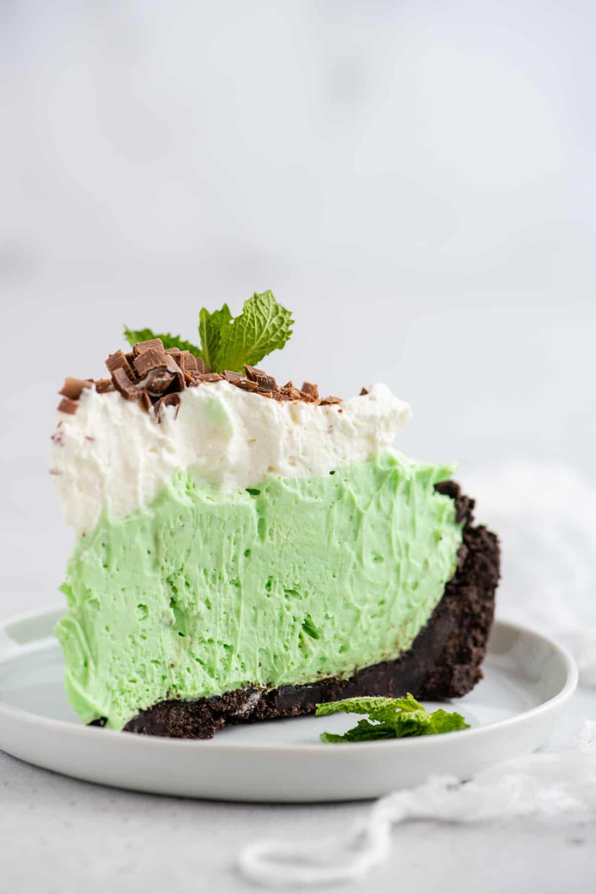 Torta Grasshopper Analcolica 4 fetta di torta alla menta verde su piatto bianco su sfondo bianco