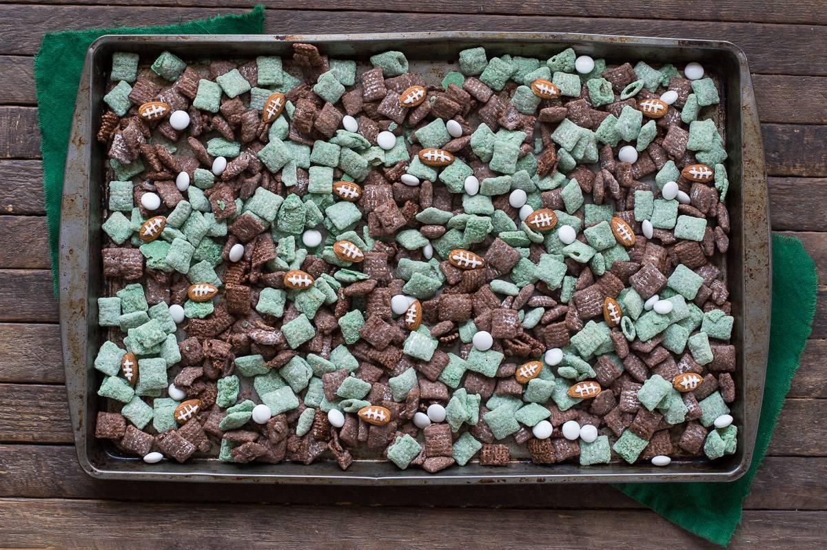 Calcio Puppy Chow 4 Puppy Chow Football Americano verde e marrone con mandorle a forma di pallone e bandierine Game Day su una teglia