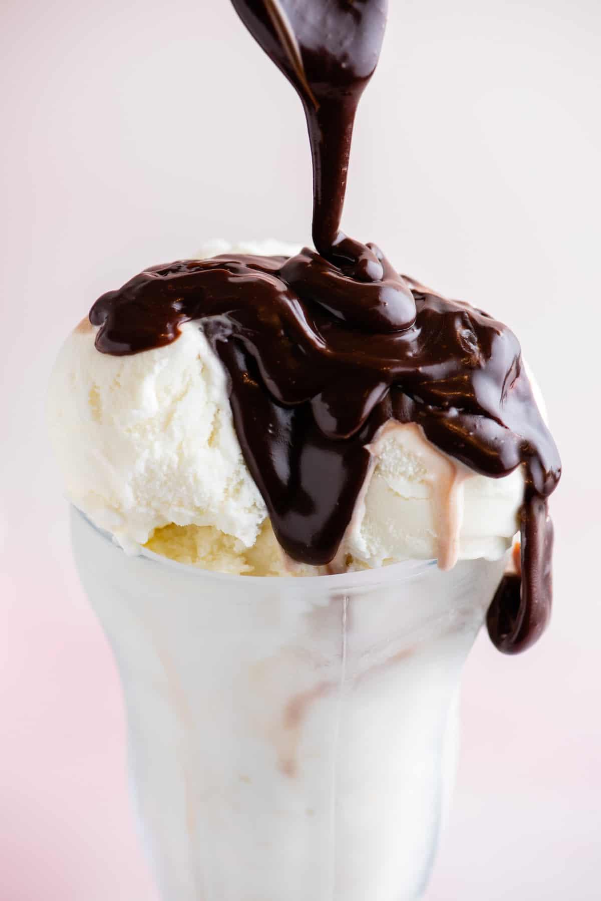 **Salsa Calda al Cioccolato Fondente** 4 Salsa hot fudge versata su gelato in una coppa di vetro