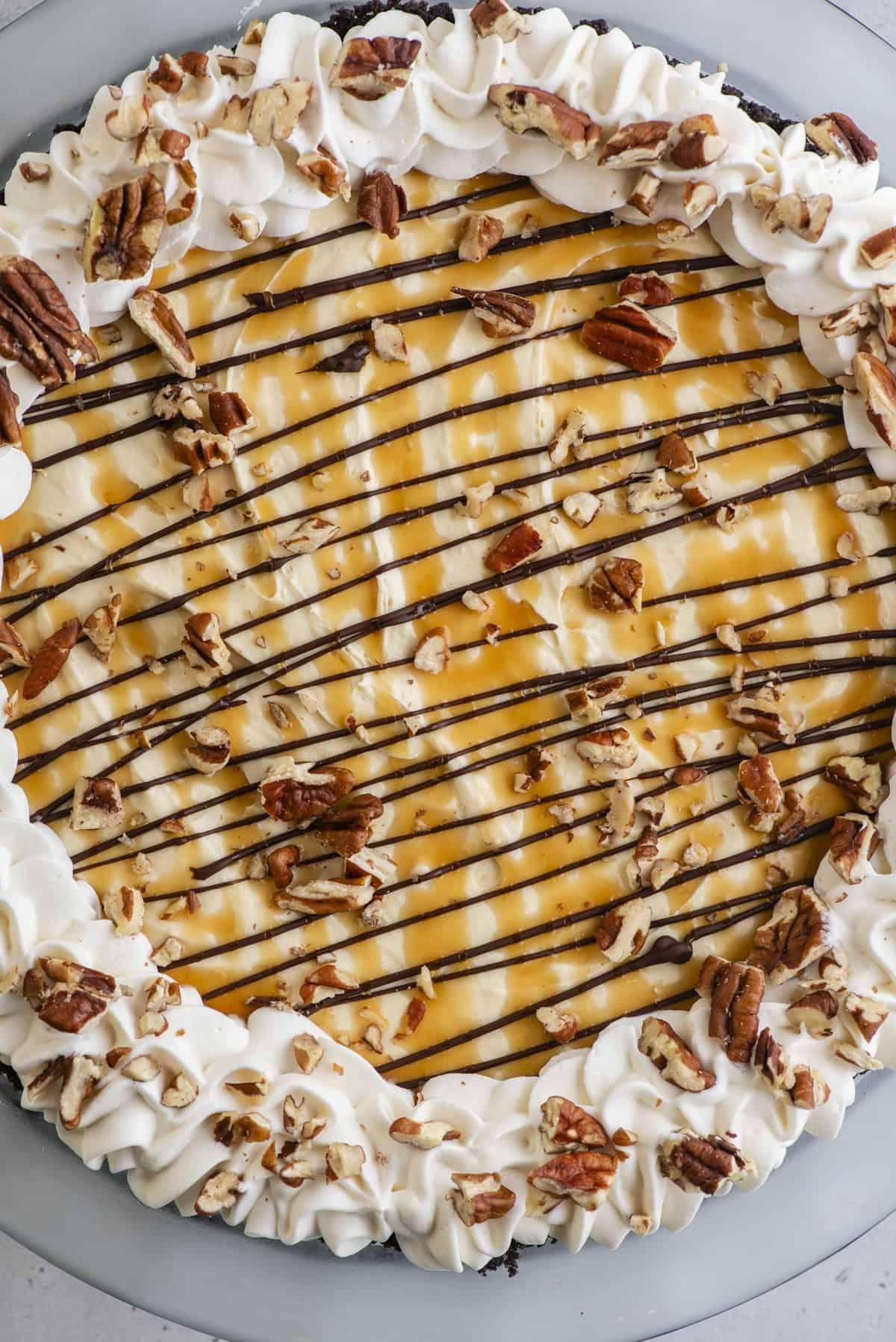 Torta di Tartaruga 4 Vista dall'alto di una Torta Tartaruga guarnita con panna montata, cioccolato, caramello e noci pecan.