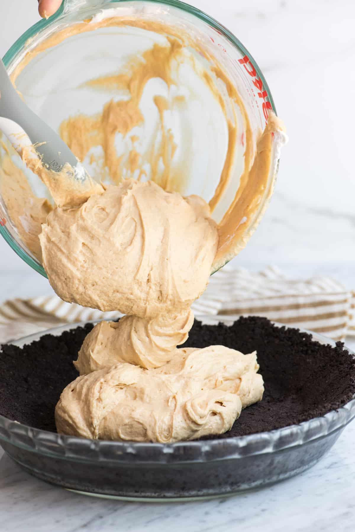Ricetta Facile di Torta al Burro di Arachidi 5 Il ripieno al burro di arachidi viene versato nella crosta di Oreo per la torta.