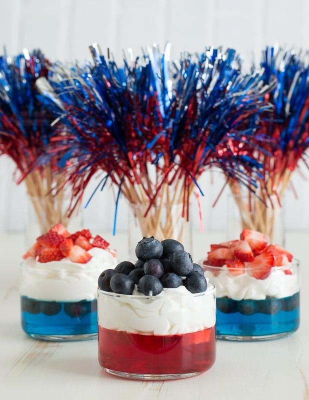 Coppette di Frutta e Gelatina per il 4 Luglio 5 Bicchierini di gelatina blu e rossa con panna montata e fragole e mirtilli tritati