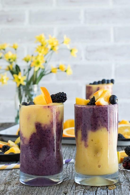 Questo smoothie hawaiano ai frutti di bosco a due strati presenta uno strato arancione al mango e uno strato ai frutti di bosco! Guarnisci lo smoothie con uno spiedino di frutta fresca!