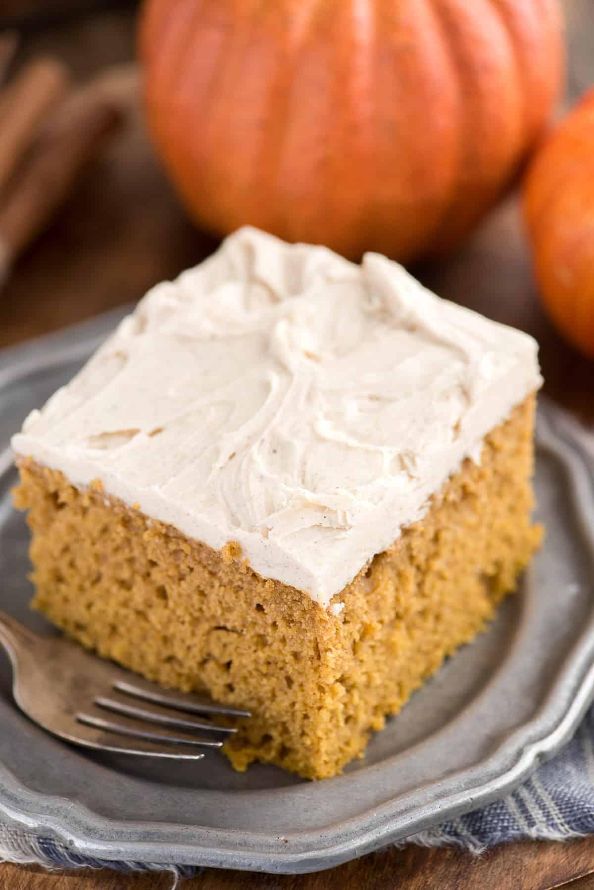 Facile Torta di Zucca da Mix 5 fetta di torta di zucca su piatto di metallo con zucca sullo sfondo