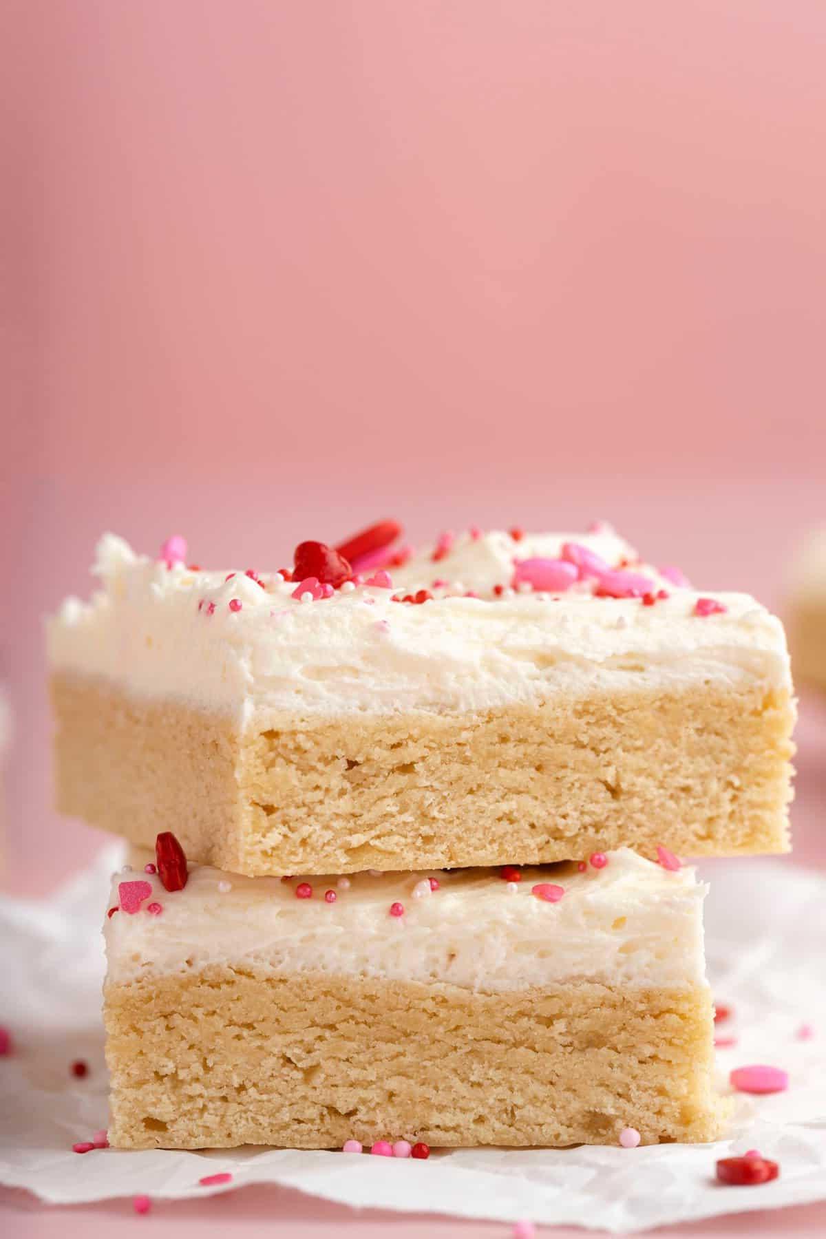 Quadrotti di Biscotti di Zucchero di San Valentino 5 due barrette di biscotto zuccherato con glassa bianca e confettini a tema San Valentino su sfondo rosa