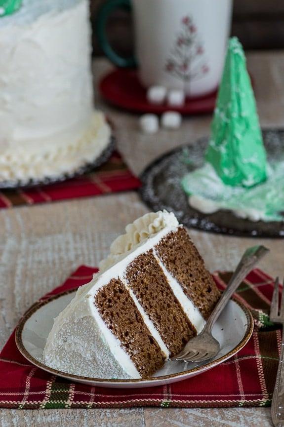Primo piano degli alberi di Natale commestibili glassati di verde e spolverati di zucchero a velo, posizionati sulla torta di pan di zenzero