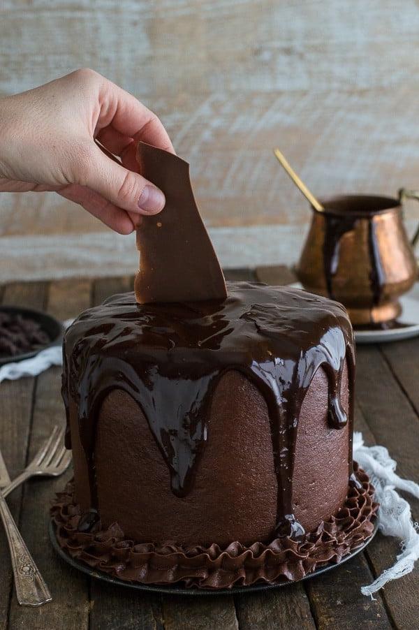 Inserimento di una scaglia di cioccolato nella Torta al Cioccolato Cioccolato per la decorazione.