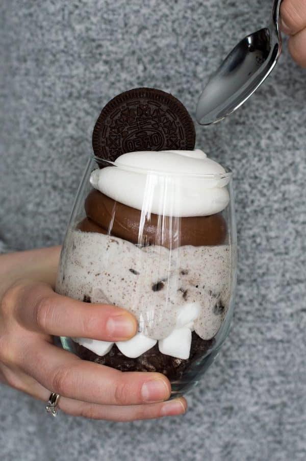 Primo piano di un parfait al cioccolato, cheesecake e Oreo decorato, pronto per essere gustato