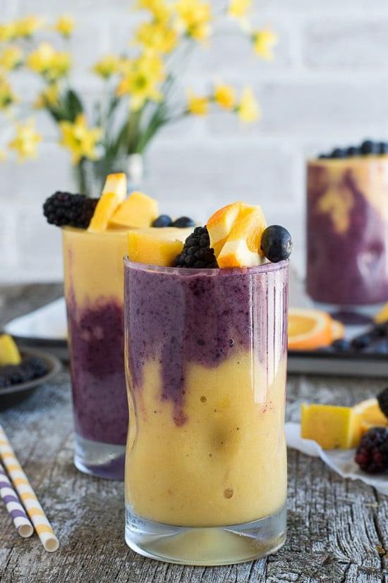 Frullato Hawaiano di Bacche 6 Questo smoothie hawaiano ai frutti di bosco a due strati presenta uno strato arancione al mango e uno strato ai frutti di bosco! Guarnisci lo smoothie con uno spiedino di frutta fresca!