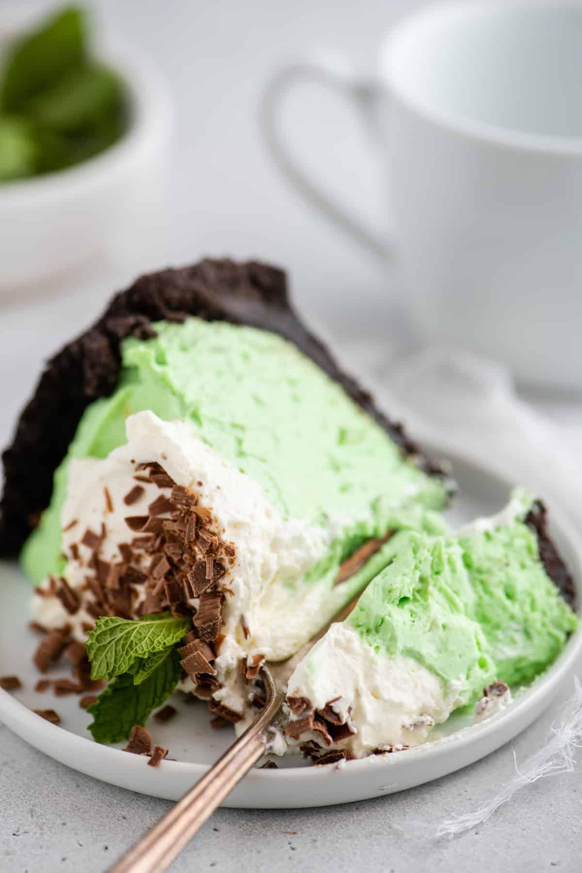 Torta Grasshopper Analcolica 6 fetta di torta alla menta verde su piatto bianco su sfondo bianco