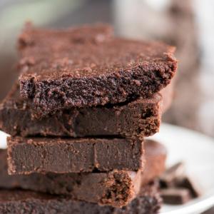 Brownies fondenti più sani 2 Cinque brownies fondenti salutari fatti in casa su un piatto da portata bianco.
