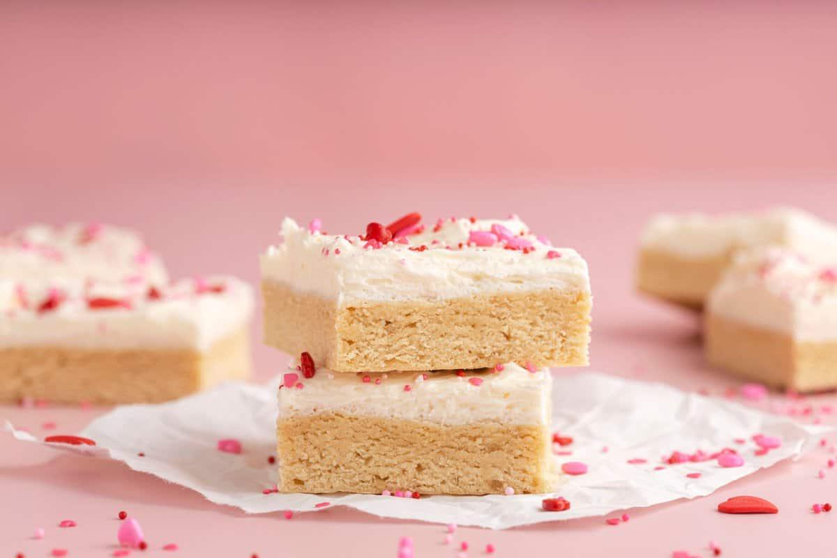 Quadrotti di Biscotti di Zucchero di San Valentino 6 due barrette di biscotto zuccherato con glassa bianca e confettini a tema San Valentino su sfondo rosa