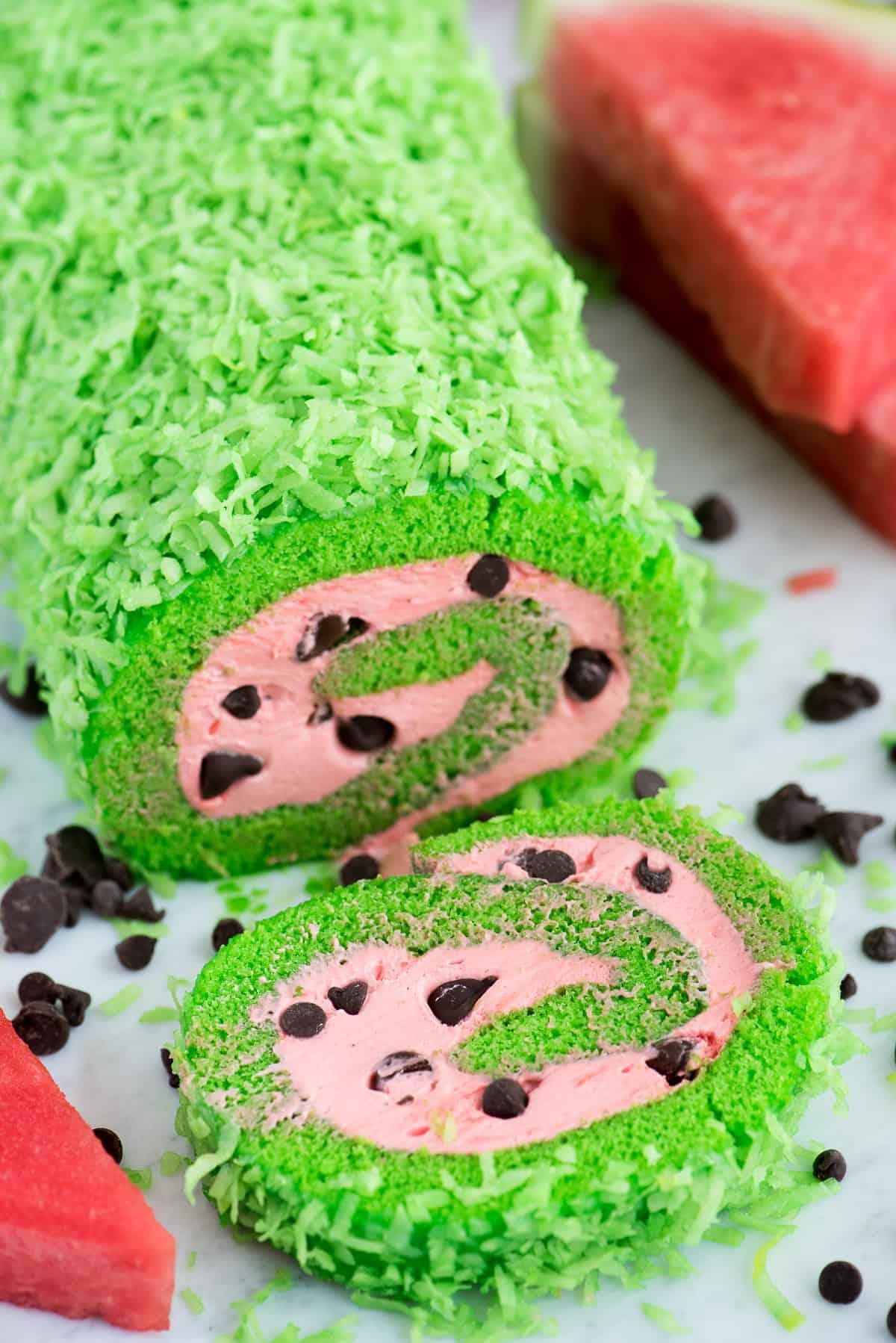 Una torta rotolo anguria già completata, con la sua caratteristica colorazione verde all'esterno e il ripieno rosso/rosa con i semi di cioccolato, pronta per essere servita o fotografata.