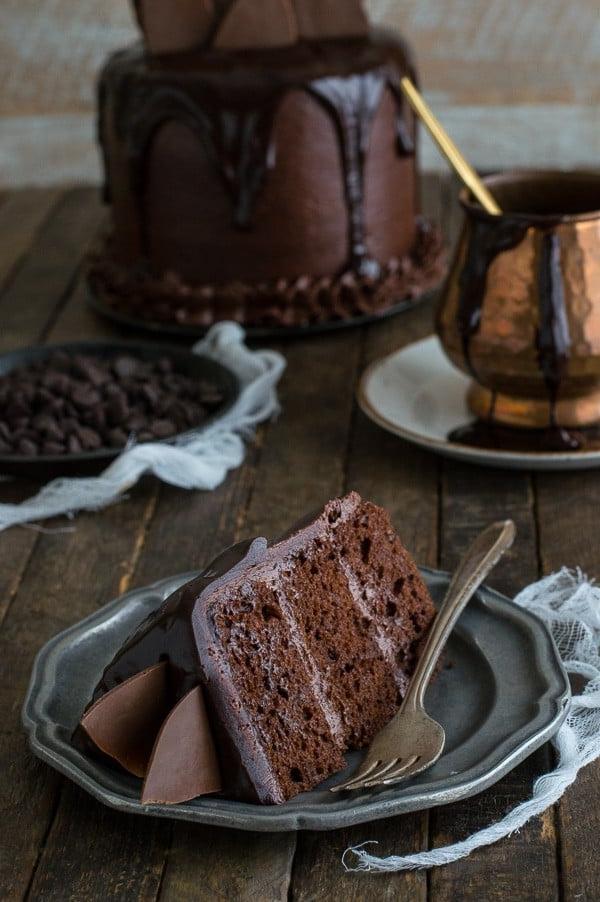 Torta al Cioccolato Cioccolato - Una fetta di paradiso. Una fetta di Torta al Cioccolato Cioccolato con ganache al cioccolato e scaglie di cioccolato su un piccolo piatto da portata.