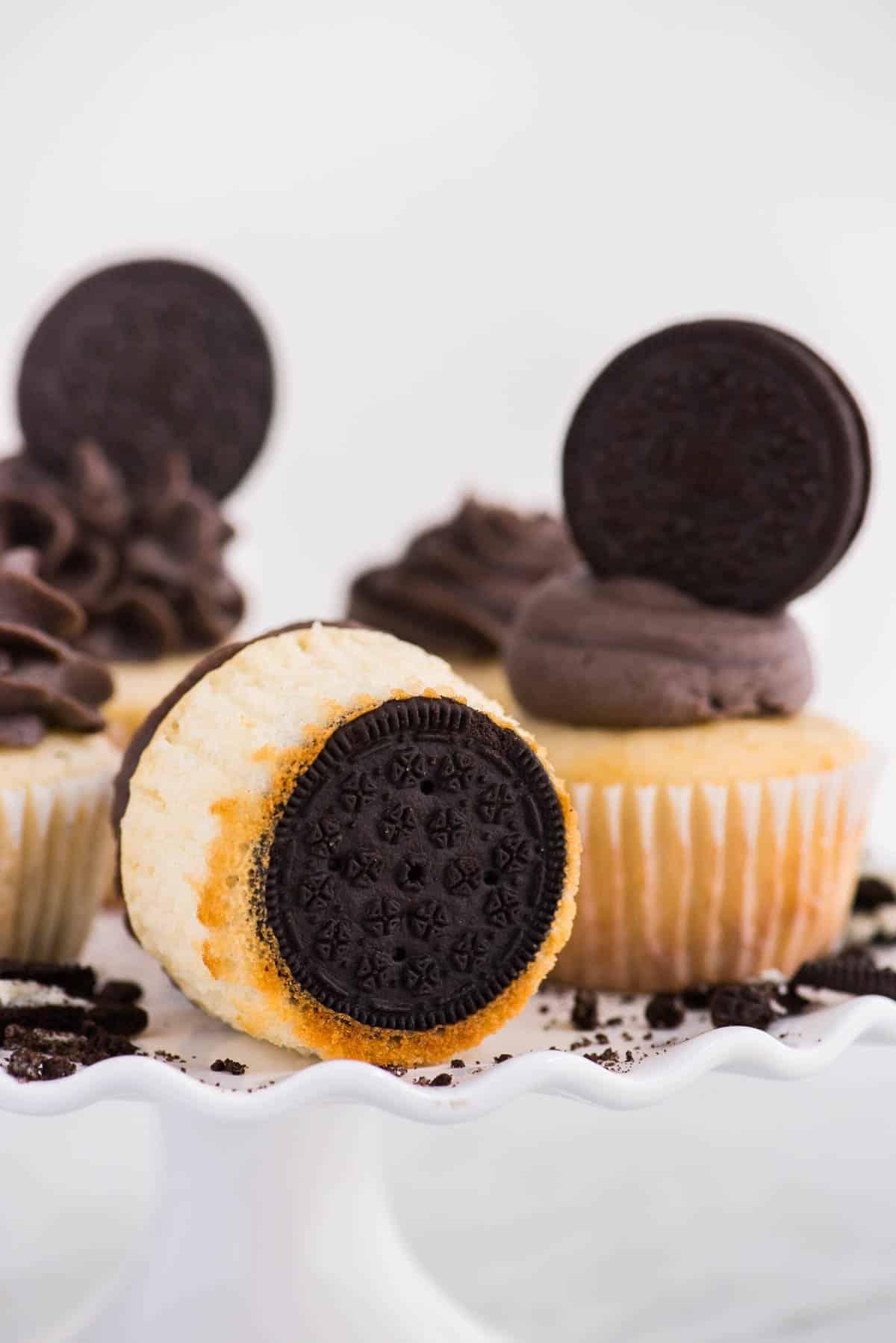 Cupcakes con base Oreo 6 Cupcakes alla vaniglia con fondo Oreo su alzata bianca su sfondo bianco