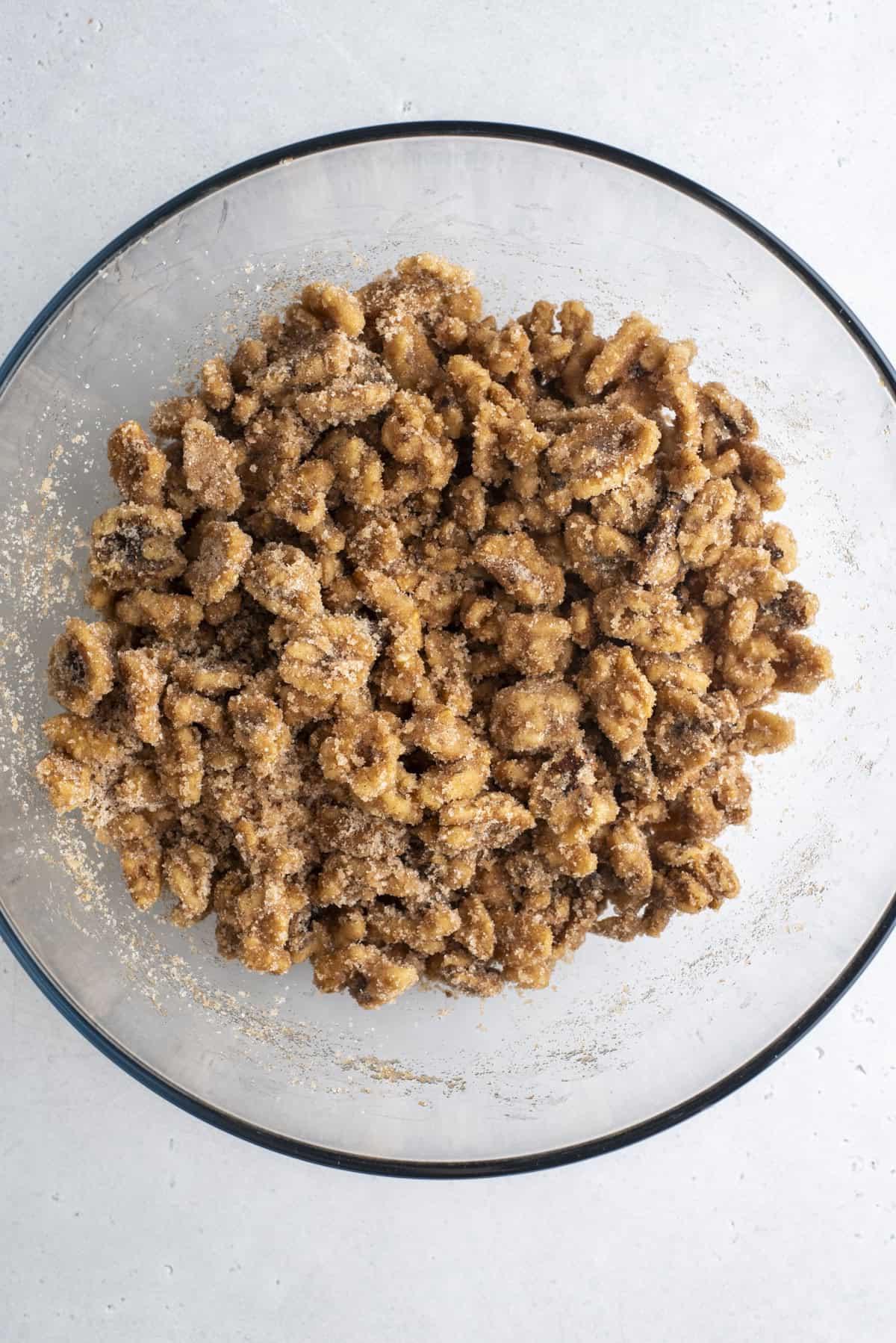 noci ricoperte da una miscela di zucchero e cannella in una ciotola di vetro