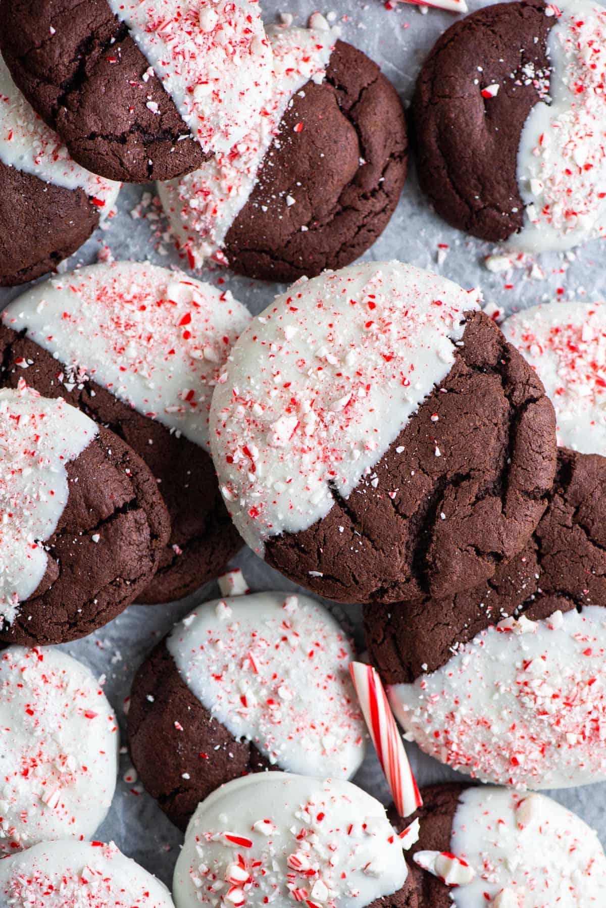 Questi Biscotti al Cioccolato e Bastoncini di Zucchero sono morbidi, gommosi, immersi nel cioccolato bianco e cosparsi di bastoncini di zucchero tritati. Vista dall'alto di biscotti al cioccolato e bastoncini di zucchero