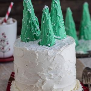 Torta di pan di zenzero a strati con glassa alla vaniglia e decorazioni festive, presentata su un piatto